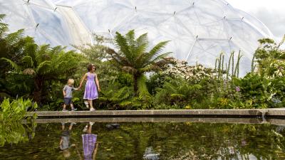 Two children exploring the Outdoor Gardens with Biome in background